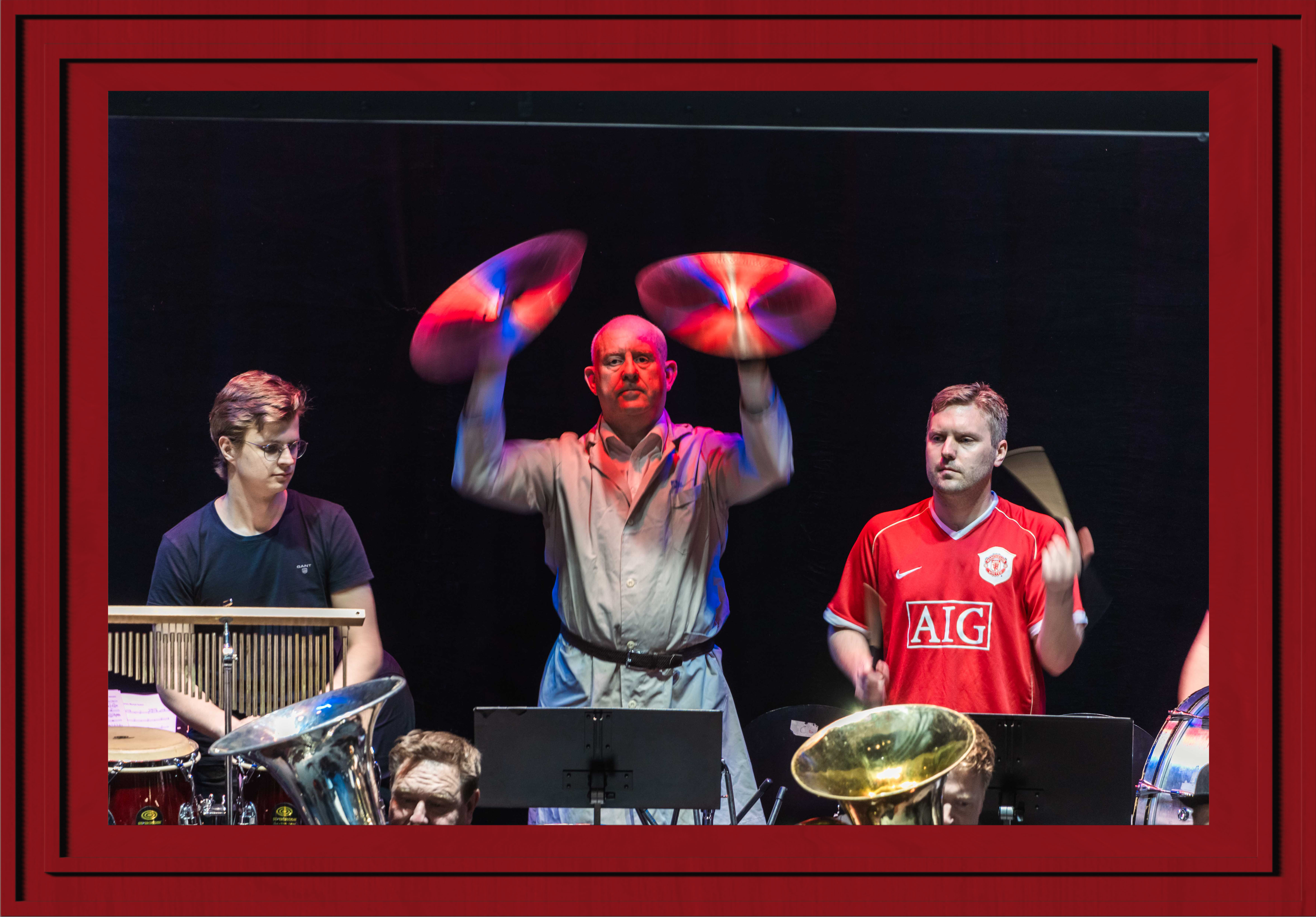 A musician hitting a pair of cymbals