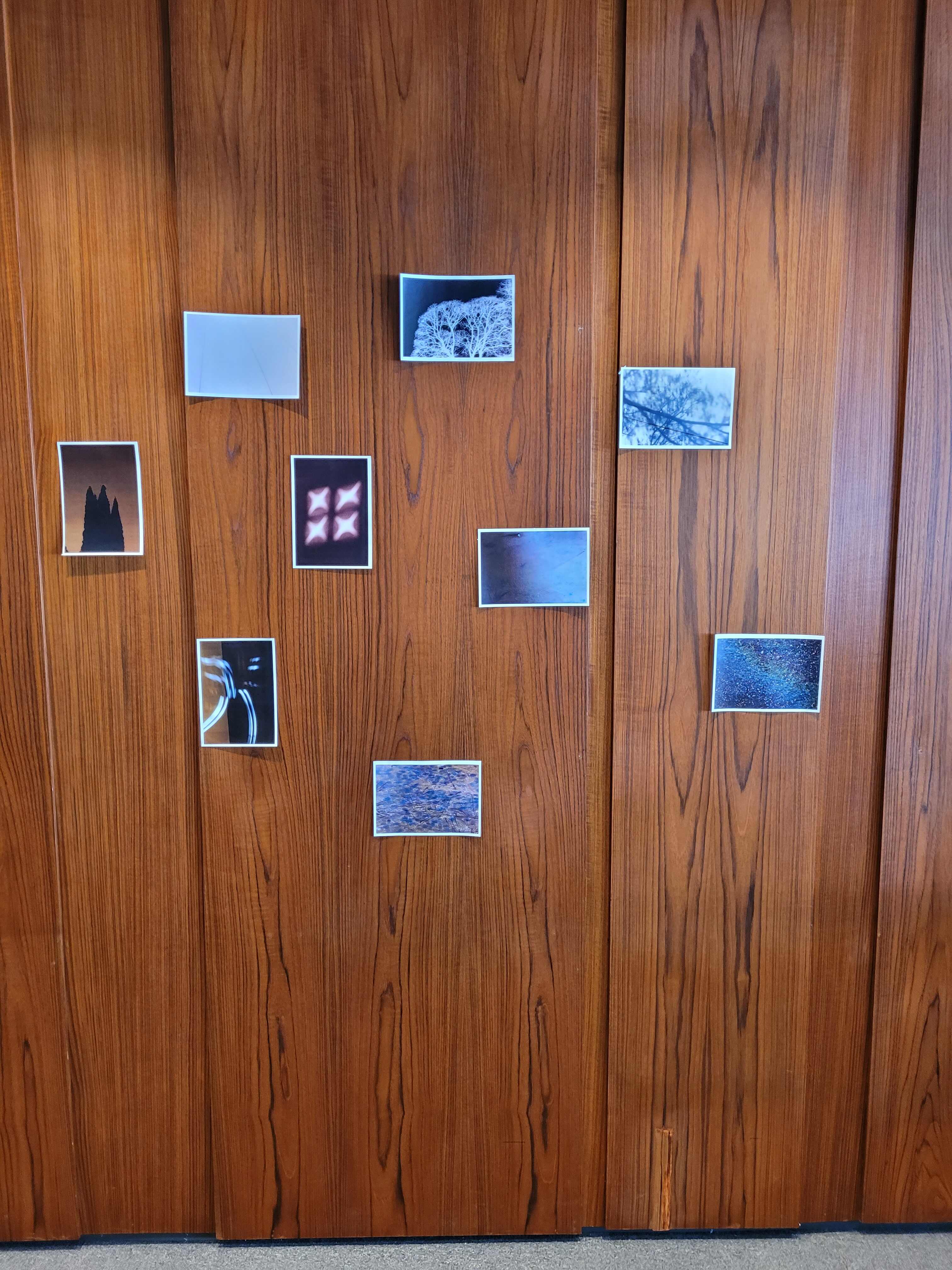 A selection of abstract photos taped to a wooden wall