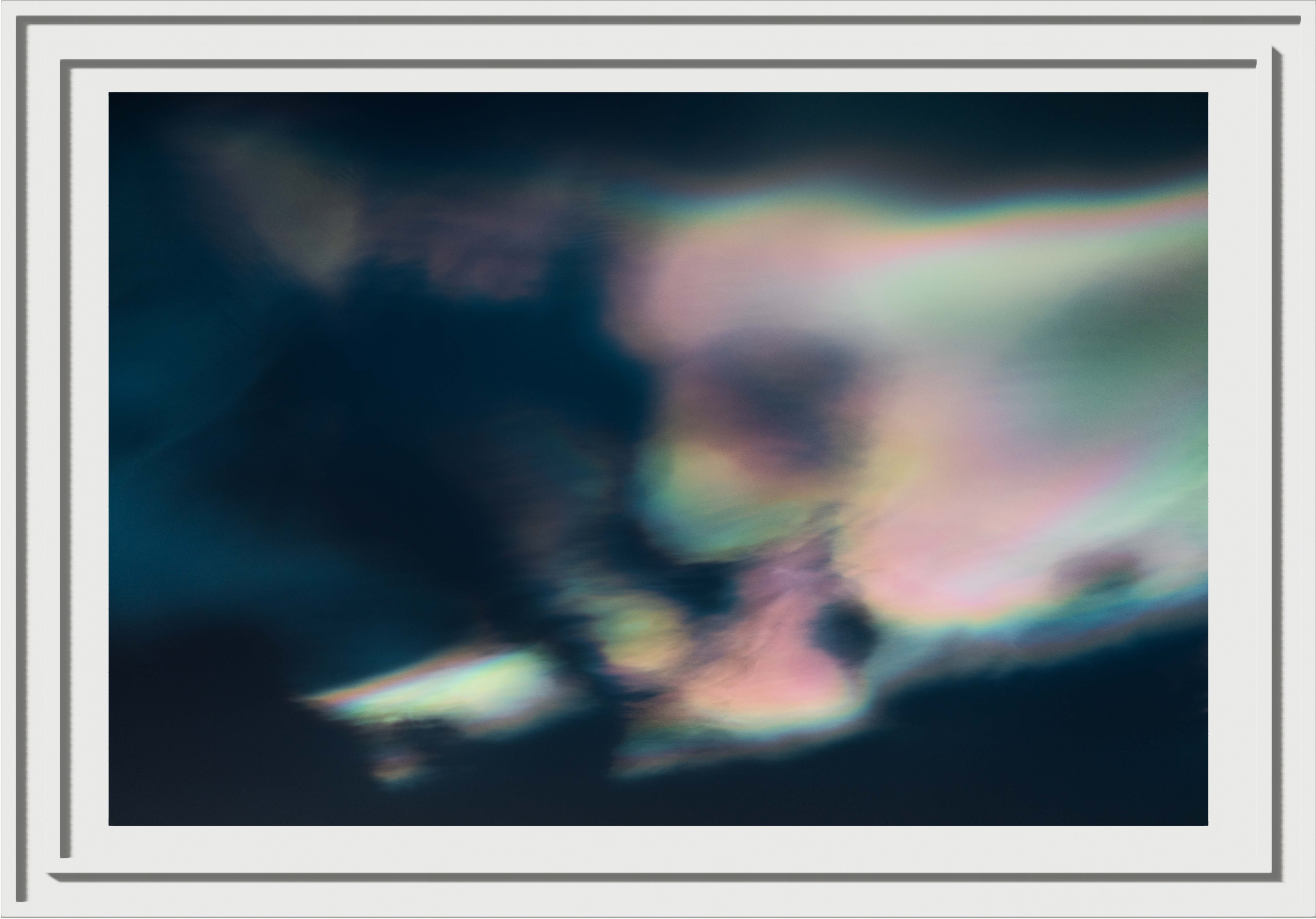 Silky diffused rainbow clouds, almost resmbling a skull? in a white frame